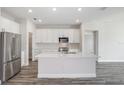 Modern kitchen with white cabinets, stainless steel appliances, and a large island at 10317 Fieldstone Myrtle Way, San Antonio, FL 33576