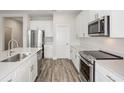 Modern kitchen with white cabinets, stainless steel appliances and an island at 10317 Fieldstone Myrtle Way, San Antonio, FL 33576