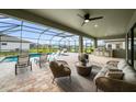 Spacious screened-in patio featuring a pool, seating area, and outdoor kitchen overlooking water at 9120 Warm Springs Cir, Parrish, FL 34219