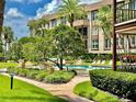 Community pool with lounge chairs and lush landscaping at 3035 Countryside Blvd # 14B, Clearwater, FL 33761