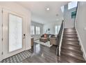 Bright and airy entryway with hardwood floors, staircase, and cozy sitting area at 5112 Coastal Scene Dr, Apollo Beach, FL 33572