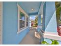 Charming light blue front porch with white columns and landscaping at 5112 Coastal Scene Dr, Apollo Beach, FL 33572
