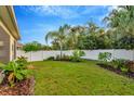 Landscaped backyard with lush greenery and a white privacy fence at 121 Lacewing Pl, Valrico, FL 33594