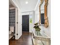 Welcoming foyer featuring hardwood flooring, decorative mirror, and a convenient powder room at 2527 W Maryland Ave # A, Tampa, FL 33629