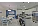 Modern kitchen with white cabinets, granite island, and stainless steel appliances at 806 Chipper Dr, Sun City Center, FL 33573