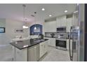 Modern kitchen with white cabinets, granite island, and stainless steel appliances at 806 Chipper Dr, Sun City Center, FL 33573