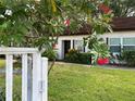 Charming single-story home with well-maintained lawn, blossoming trees, and a welcoming entrance at 3157 Mission Grove Dr, Palm Harbor, FL 34684