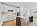 Modern kitchen with white cabinets, quartz countertops, and a large island at 1692 Fallon Pass, Zephyrhills, FL 33541