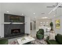 Living room features a modern fireplace, green armchairs, and a formal dining area at 2221 S Village Ave, Tampa, FL 33612