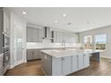 Spacious kitchen with gray cabinets, island, and quartz countertops at 3437 Yellow Leaf Cir, Spring Hill, FL 34609