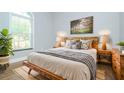 Well-lit bedroom with a rustic wooden bed frame and neutral-toned decor at 803 W Sligh Ave, Tampa, FL 33604