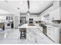 Modern kitchen featuring white cabinets, marble countertops, and a large island at 12506 Ashdown Dr, Odessa, FL 33556