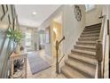Bright foyer with views of the stairway, half bath, and decorator-designed wall at 16462 Courtyard Loop, Land O Lakes, FL 34638