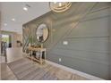 Beautiful hallway featuring decorative wall paneling and stylish lighting fixtures at 16462 Courtyard Loop, Land O Lakes, FL 34638