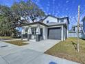 New construction home with a gray door and attached garage at 2404 1/2 E Chelsea, Tampa, FL 33610