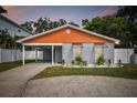 Modern house with gray and orange exterior, landscaped yard, and driveway at 4607 W San Jose St, Tampa, FL 33629