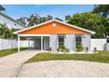 Modern house with gray and orange exterior, landscaped yard, and driveway at 4607 W San Jose St, Tampa, FL 33629