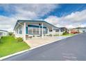 White manufactured home with blue accents and a covered carport at 7141 El Matador St, Zephyrhills, FL 33541