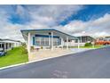 White manufactured home with blue trim and a covered carport at 7141 El Matador St, Zephyrhills, FL 33541