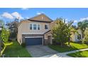 Two-story house with a stone and beige exterior, two-car garage, and landscaping at 3147 Calvano Dr, Land O Lakes, FL 34639