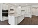 Modern kitchen with white cabinets, quartz countertops, and stainless steel appliances at 1686 Fallon Pass, Zephyrhills, FL 33541