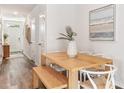 Bright dining area with a wooden table, bench seating, and a contemporary chandelier at 4211 Red Banks Ln, Bradenton, FL 34208