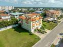 Expansive aerial view of the Mediterranean-style home situated on a corner lot with lush green lawns, set in a residential area at 136 175Th E Ave, Redington Shores, FL 33708