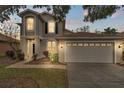 Two-story house with gray siding, white garage door, and landscaping at 10142 Kingsbridge Ave, Tampa, FL 33626