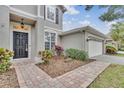 House exterior featuring a walkway, landscaping, and a two-car garage at 10142 Kingsbridge Ave, Tampa, FL 33626