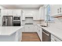 Modern kitchen with white cabinets, quartz countertops, and stainless steel appliances at 9415 Coastline Way, Parrish, FL 34219