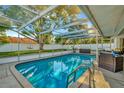 Enclosed pool area featuring a bright blue in-ground pool, cage, and outdoor furniture at 13084 Drysdale St, Spring Hill, FL 34609