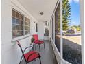 Inviting front porch with red chairs and screened enclosure at 3247 Kimberly Oaks Dr, Holiday, FL 34691