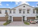 Three-unit townhouse building with brown garage doors and a car parked in the driveway at 11516 Bellamar St, Temple Terrace, FL 33637