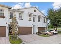 Three-unit townhouse building with brown garage doors and cars parked at 11516 Bellamar St, Temple Terrace, FL 33637