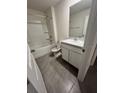 Well-lit bathroom featuring a shower-tub combo, vanity with sink, and tiled flooring at 5695 Barakat Rd, Zephyrhills, FL 33541