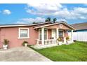 Pink stucco house with white columns and a landscaped yard at 6906 N Clark Ave, Tampa, FL 33614