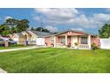 Cute pink house with white fence, landscaping, and driveway at 6906 N Clark Ave, Tampa, FL 33614