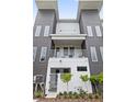 Modern two-story townhome with gray siding, white balcony, and fenced entryway at 41 29Th N St, St Petersburg, FL 33713