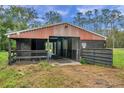 Exterior of barn with multiple stalls and covered area at 655 Appaloosa Rd, Tarpon Springs, FL 34688