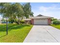 Brick ranch home with attached garage and well-manicured lawn at 1804 New Bedford Dr, Sun City Center, FL 33573