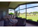 Relaxing screened porch with outdoor furniture and golf course view at 10131 Old Tampa Bay Dr, San Antonio, FL 33576