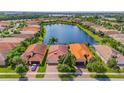 Aerial view of houses and lake in a residential community at 4949 Grand Banks Dr, Wimauma, FL 33598