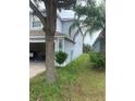 The exterior side of the home features a light-blue stucco finish and a lush green yard at 13034 Avalon Crest Ct, Riverview, FL 33579