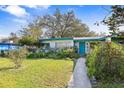 Ranch home with teal door and well-manicured lawn at 509 Langford Cir, Plant City, FL 33563