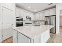 Modern kitchen with white cabinets, stainless steel appliances, and a large island at 13806 Sunlight Meadow Dr, Riverview, FL 33578