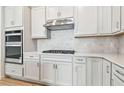 Modern kitchen with stainless steel appliances and white cabinets at 13806 Sunlight Meadow Dr, Riverview, FL 33578