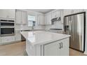 Modern kitchen with white cabinets, stainless steel appliances, and large island at 13808 Sunlight Meadow Dr, Riverview, FL 33578