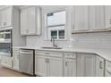 Modern kitchen with white cabinets, quartz countertops and stainless steel appliances at 13808 Sunlight Meadow Dr, Riverview, FL 33578