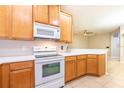 Kitchen features light wood cabinets and white appliances at 12820 Belvedere Song Way, Riverview, FL 33578