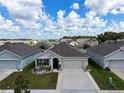 Aerial view of a single-Gathering home with a two-car garage and landscaped yard at 1523 Glen Grove Loop, Wesley Chapel, FL 33543